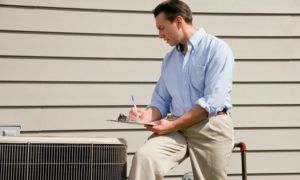 Man With Clipboard Near Air Conditioning Unit
