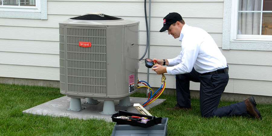 Bryant technician working on an AC unit